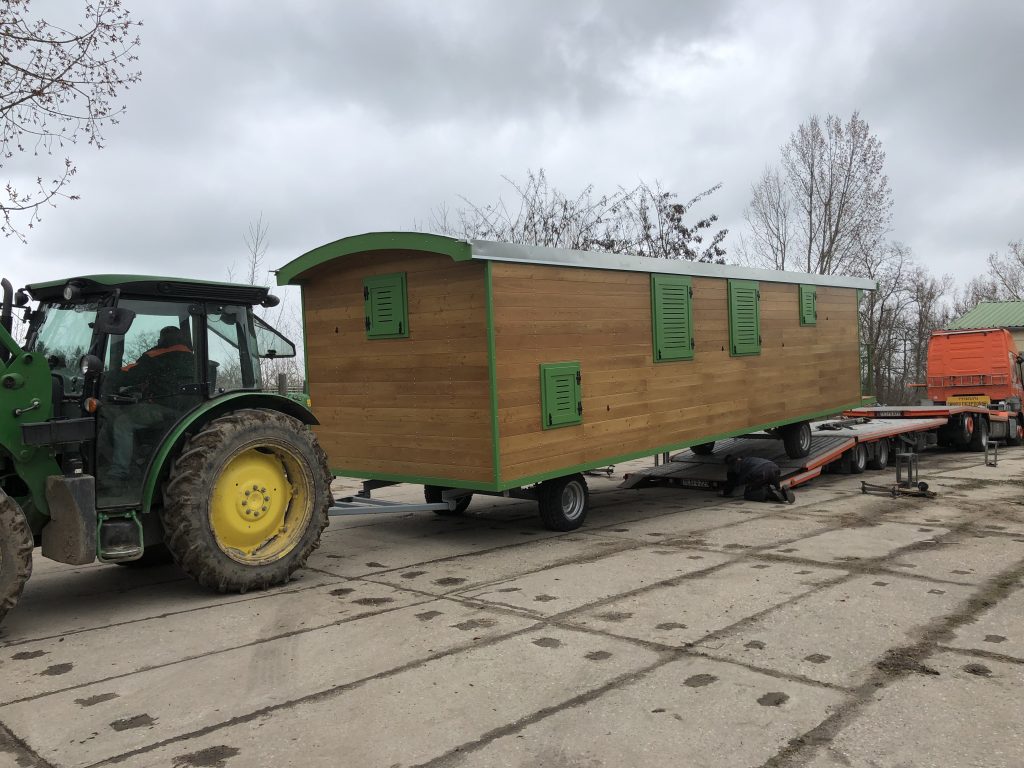 Ein Waldkindergartenwagen bei der Entladung durch einen Traktor.