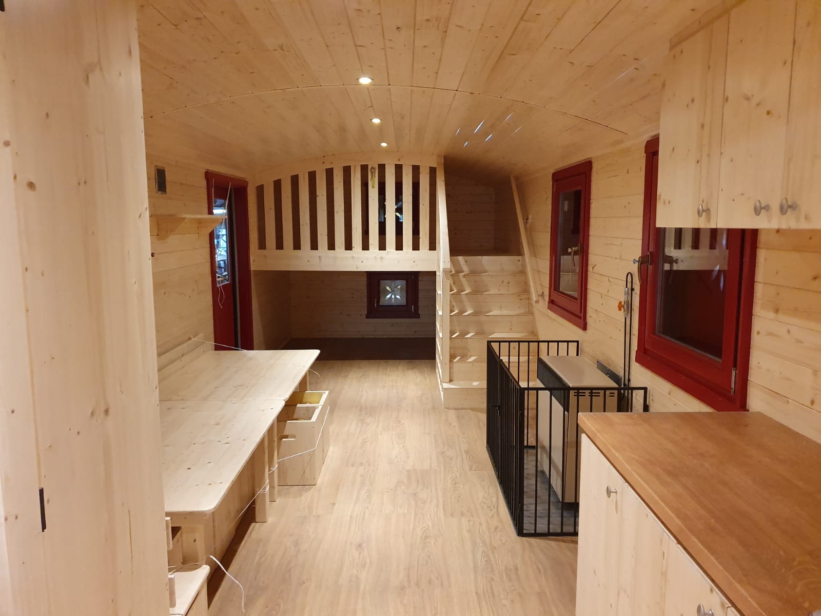 Innenraum eines NAWALO Waldkindergartenwagens mit Holzverkleidung, Sitzbank und Stauraum